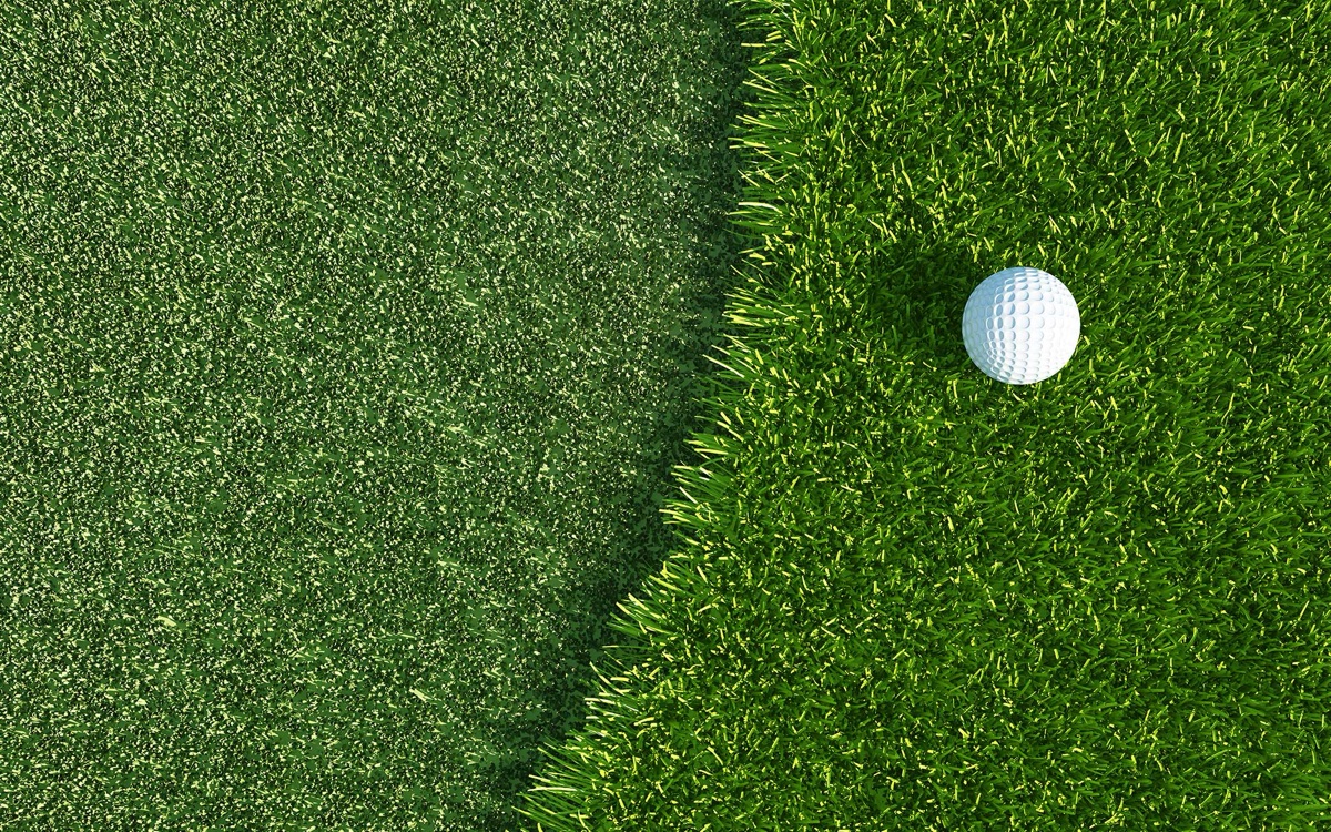 Golf ball resting on the edge between smooth fairway and taller rough grass at Furnace Brook Golf Club in Quincy, MA