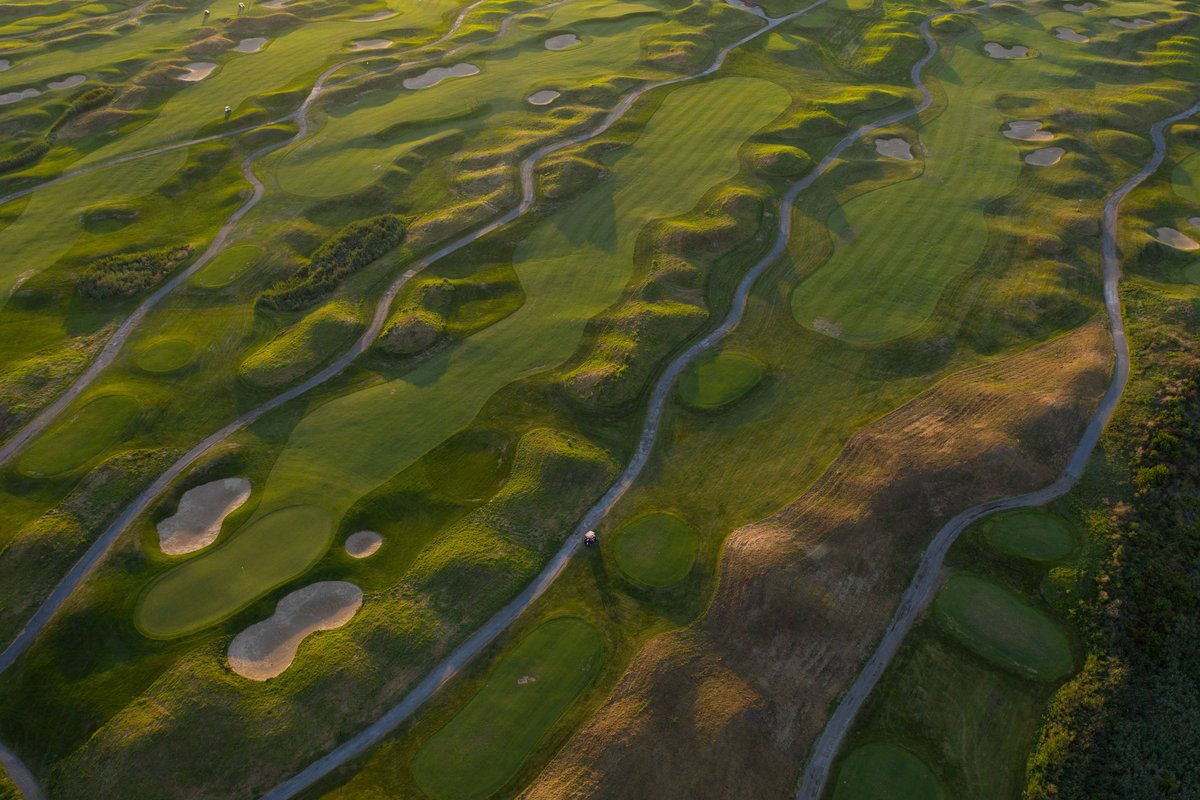 Aerial view of Pembroke Country Club in Pembroke, MA featuring rolling fairways, greens, bunkers, winding cart paths, and patchy rough.