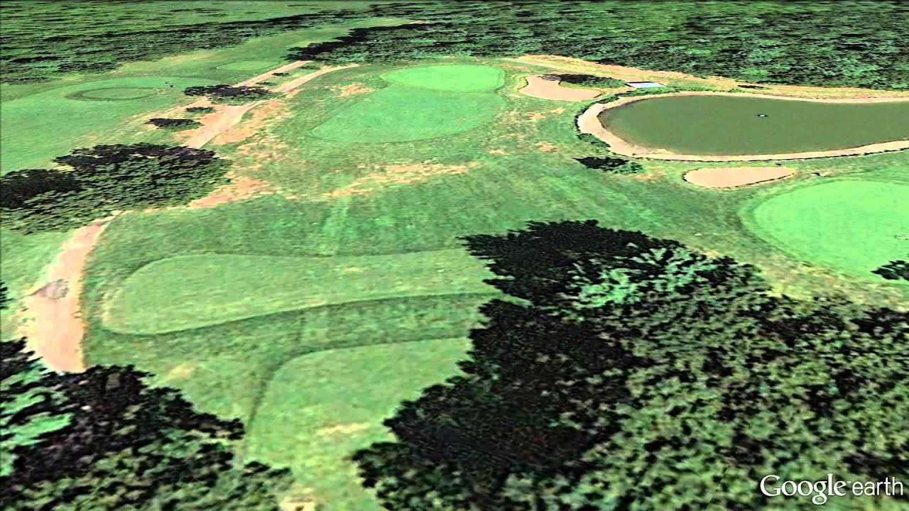 Aerial view of Sassamon Trace GC in Natick, MA featuring fairways, greens, sand bunkers, and surrounding trees.