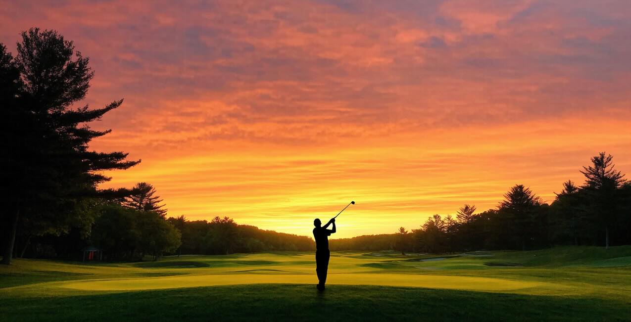 Golfer teeing off into the sunset