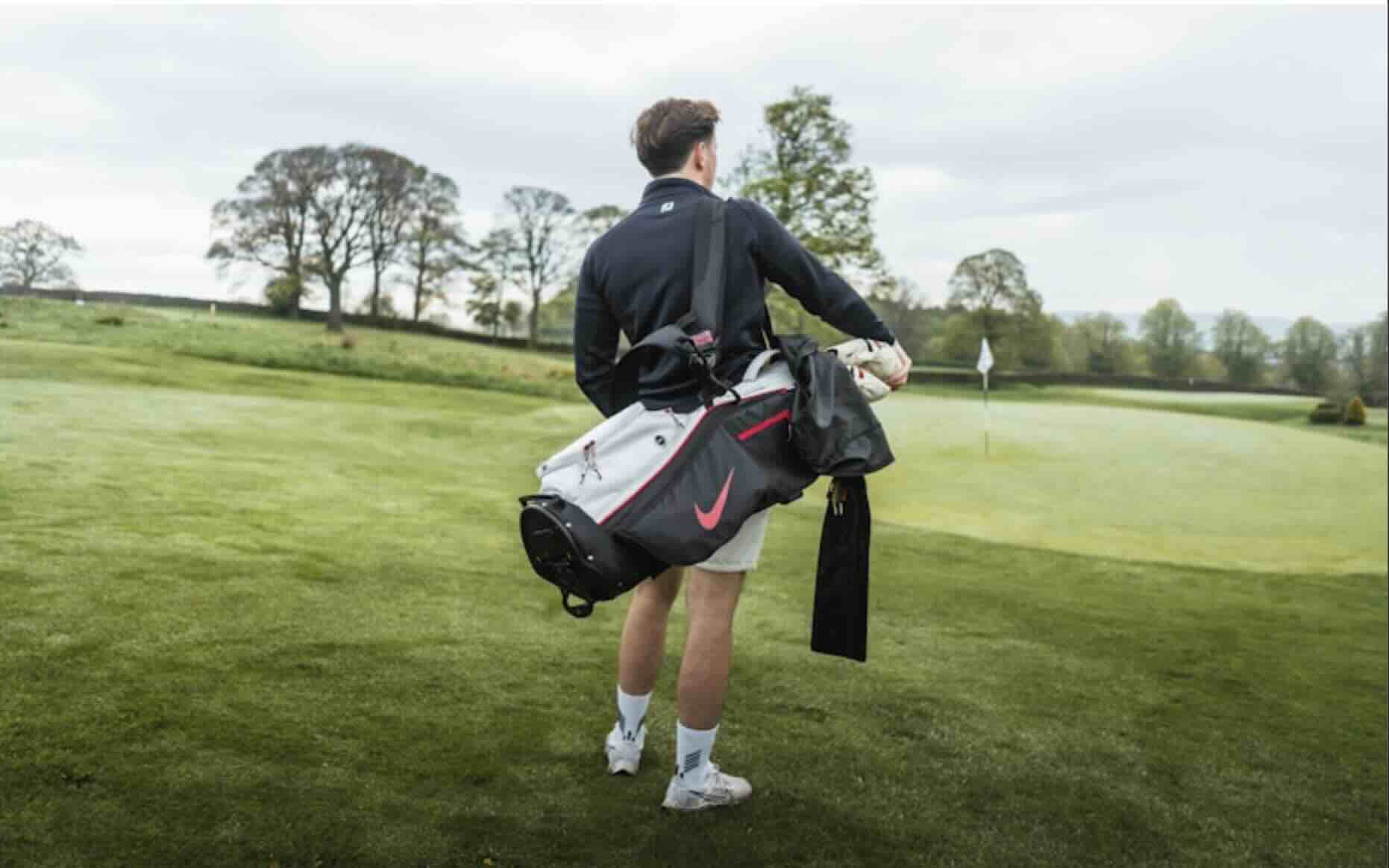 Golfer carrying a golf bag on a golf course